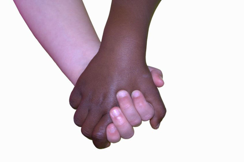biracial hands holding one another